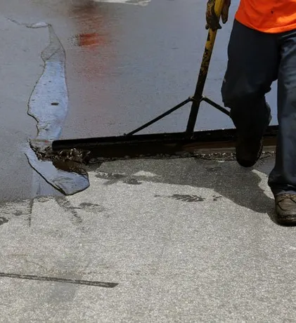 Asphalt contractor sealing a driveway in Port St Lucie, FL